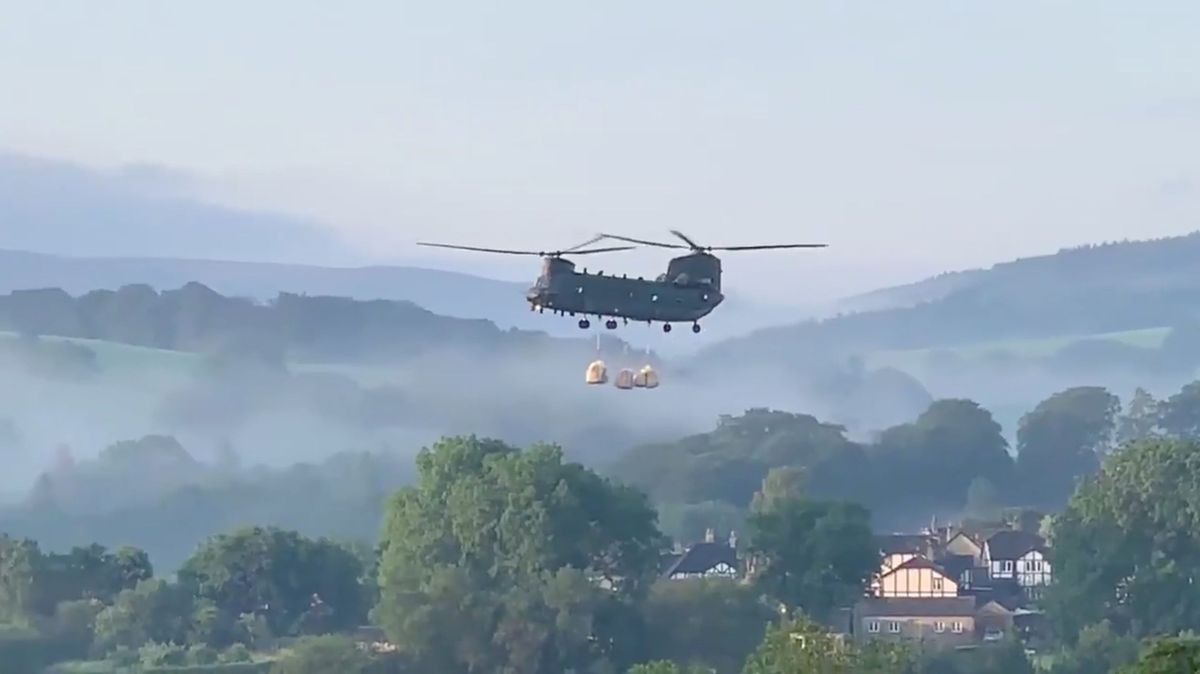 Vrtulník Chinook RAF nese pytle s pískem k poškozené hrázi