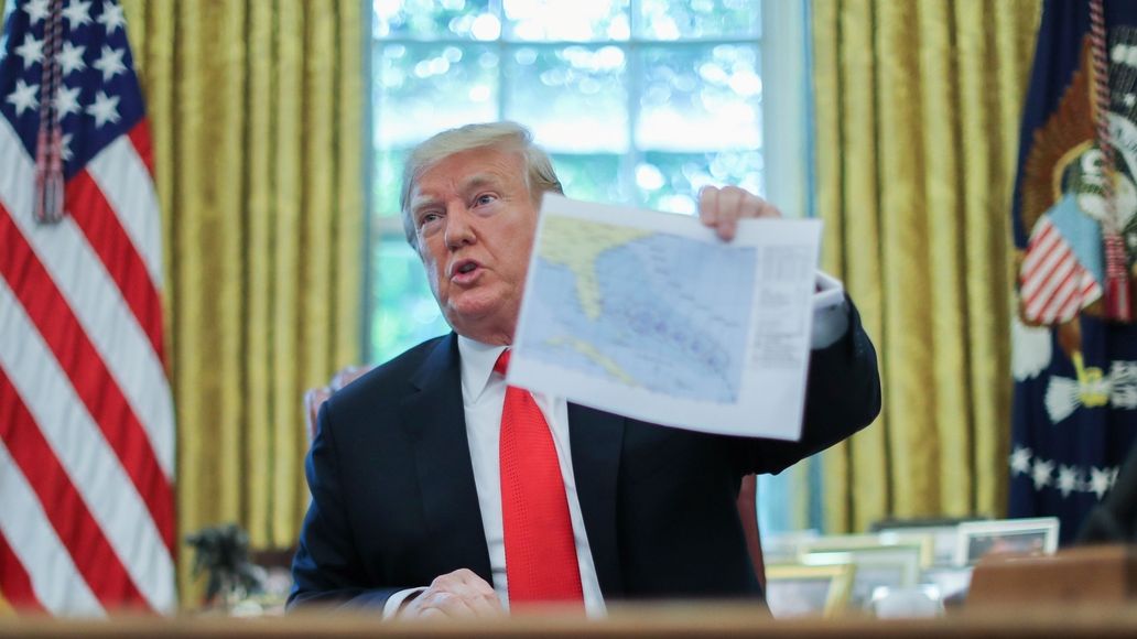 Americký prezident v Oválné pracovně ukazuje novinářům predikci trasy hurikánu Dorian.