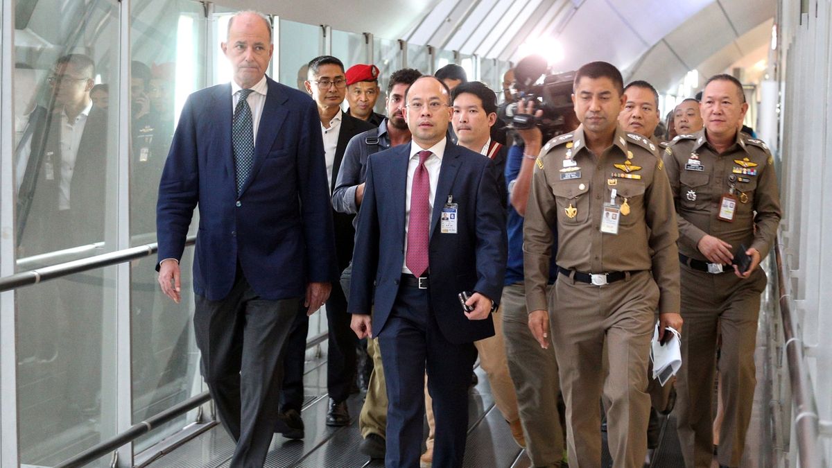 Vysoký komisař OSN pro lidská práva De Vincentiis (vlevo) jde s thajskými imigračními úředníky za Kunúnovou. 