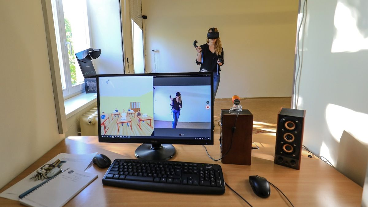 Učitel ovládá chování žáků ve virtuální třídě pomocí počítače.