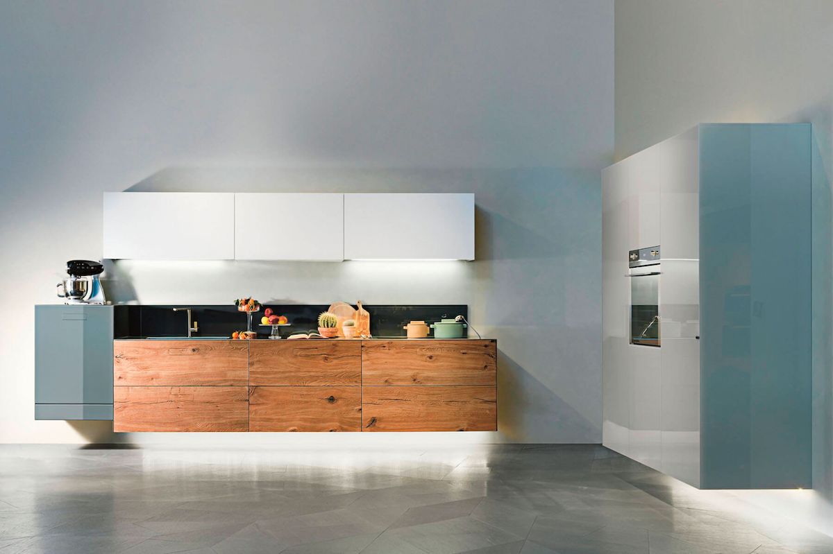 Vznášející se kuchyň díky kombinaci tradičních materiálů - skla, dřeva a nerez oceli. 