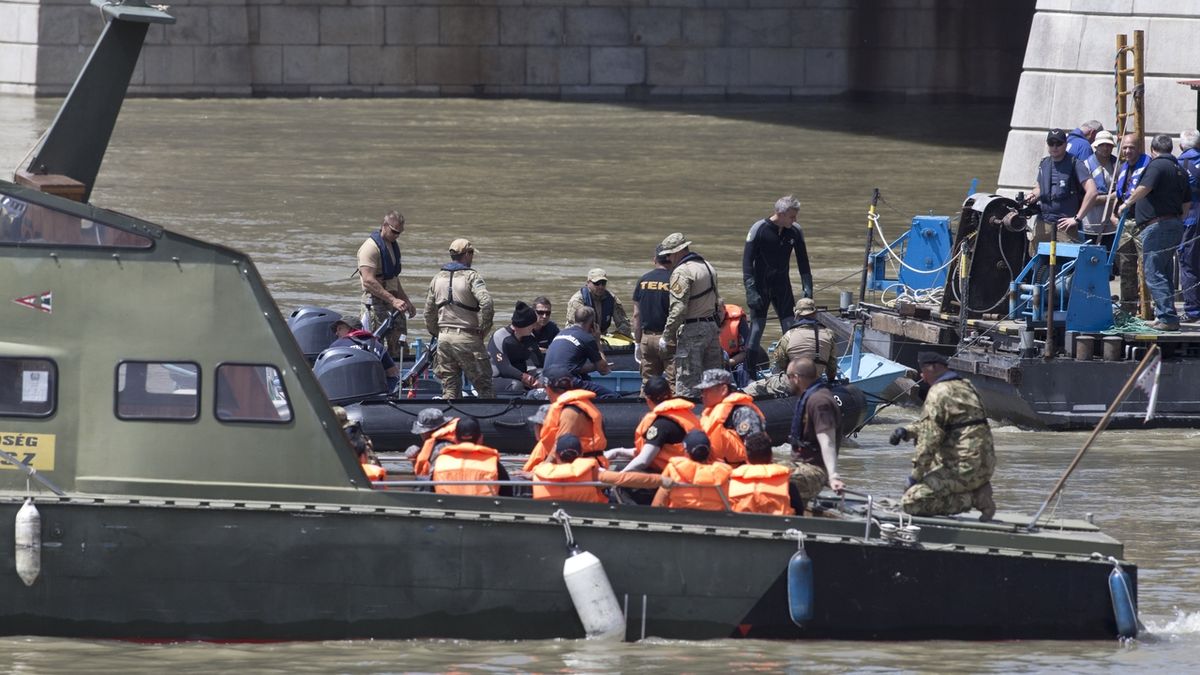 Maďarští a jihokorejští potápěči se snaží z vraku potopené lodi vyprostit těla obětí. 