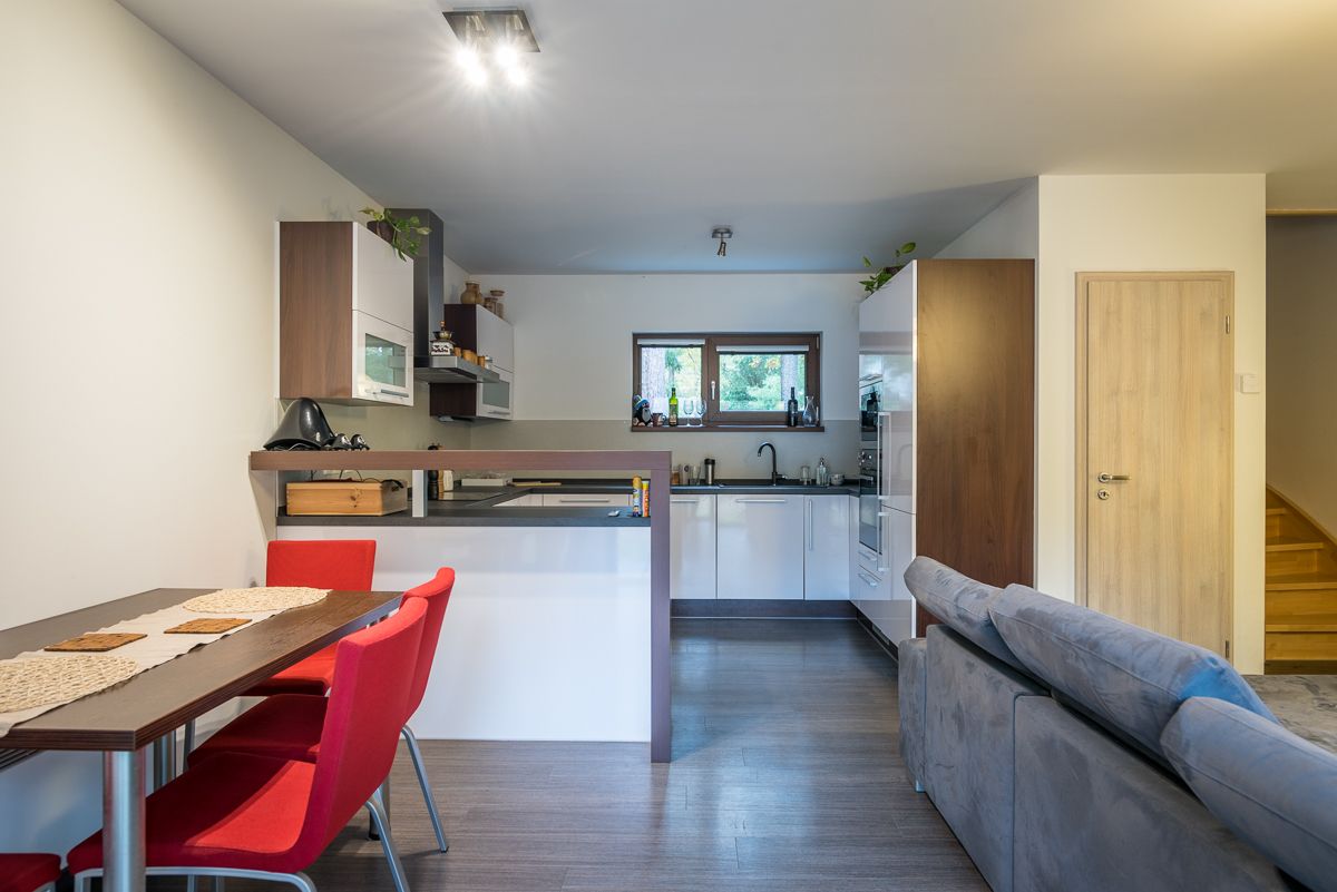 Hlavní místností přízemí je obývací pokoj propojený s kuchyní a jídelnou.