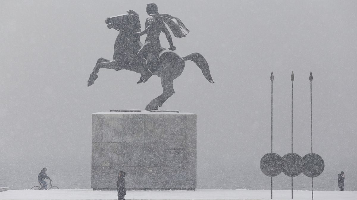 Zasněžená socha Alexandra Velikého na pobřežní promenádě v Soluni pokrývá sníh. 

