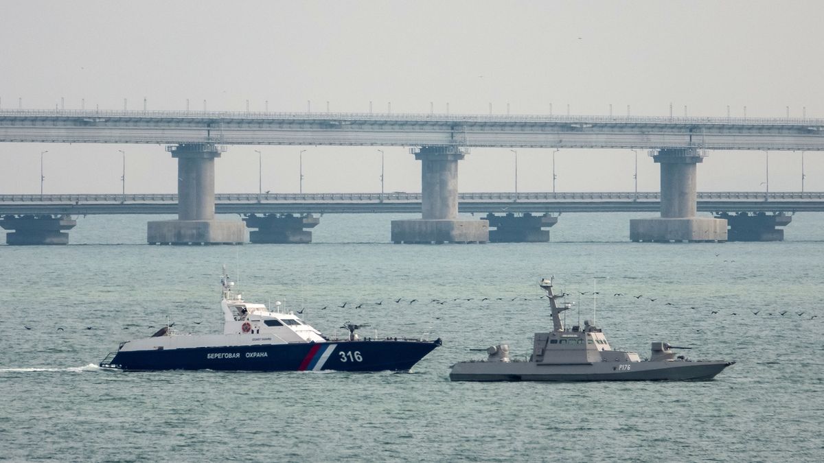 Loď ruské pobřežní stráže za ukrajinskou hlídkovou lodí u mostu přes Kerčský průliv.