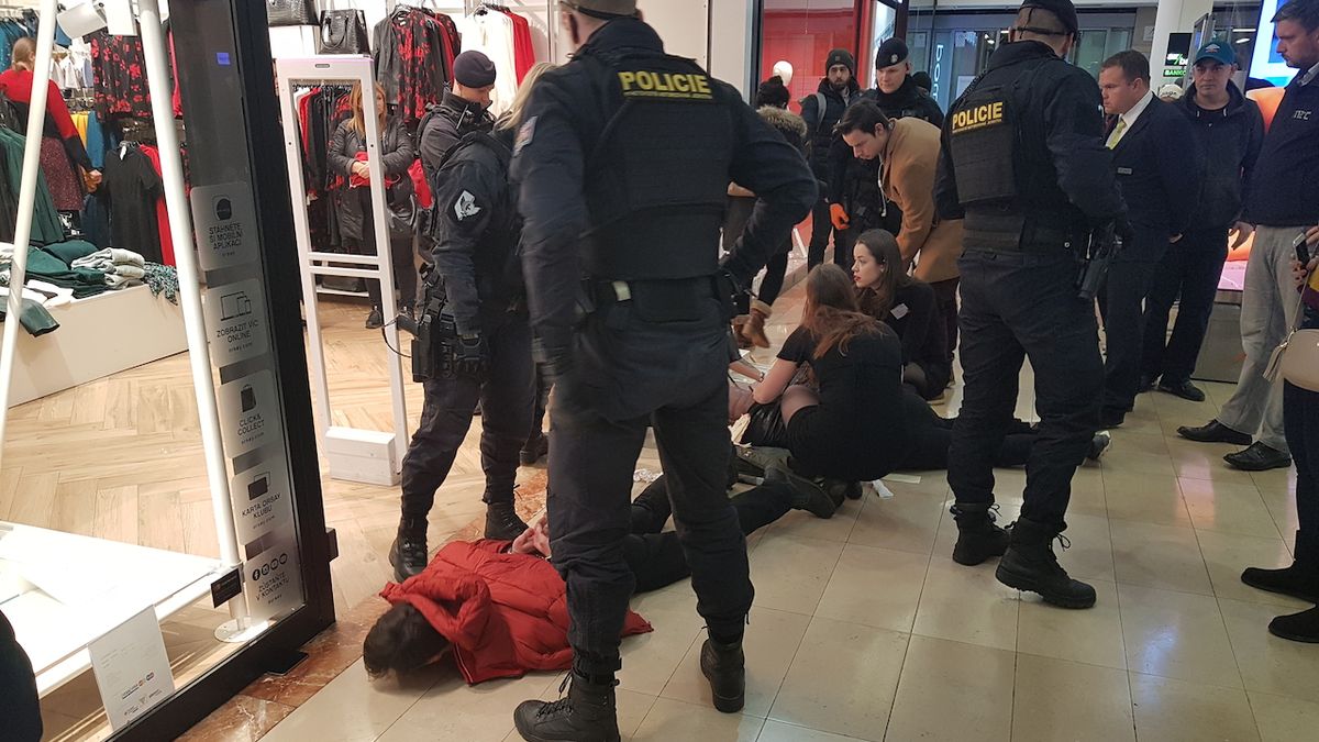 Policie na místě zadržela podezřelého (muž v červené bundě). Za ním na zemi leží pobodaný muž.