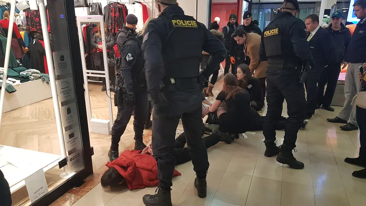 Policie na místě zadržela podezřelého (muž v červené bundě). Za ním na zemi leží pobodaný muž.