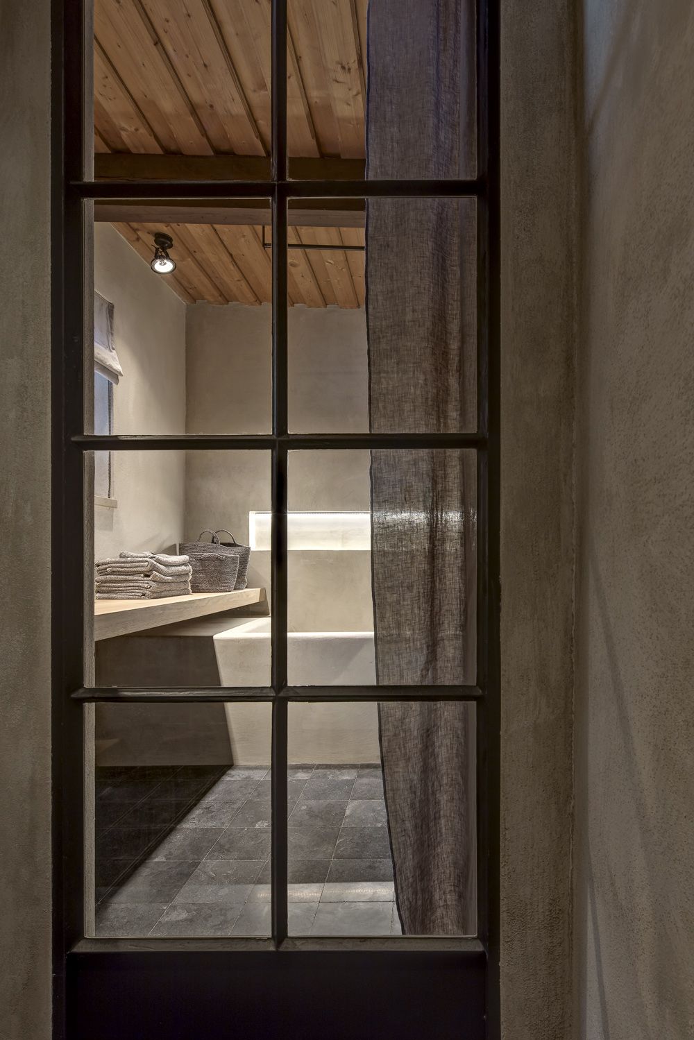 Díky velkému oknu, které představuje nejen praktický, ale i rafinovaný estetický prvek, je vidět až do koupelny. 
