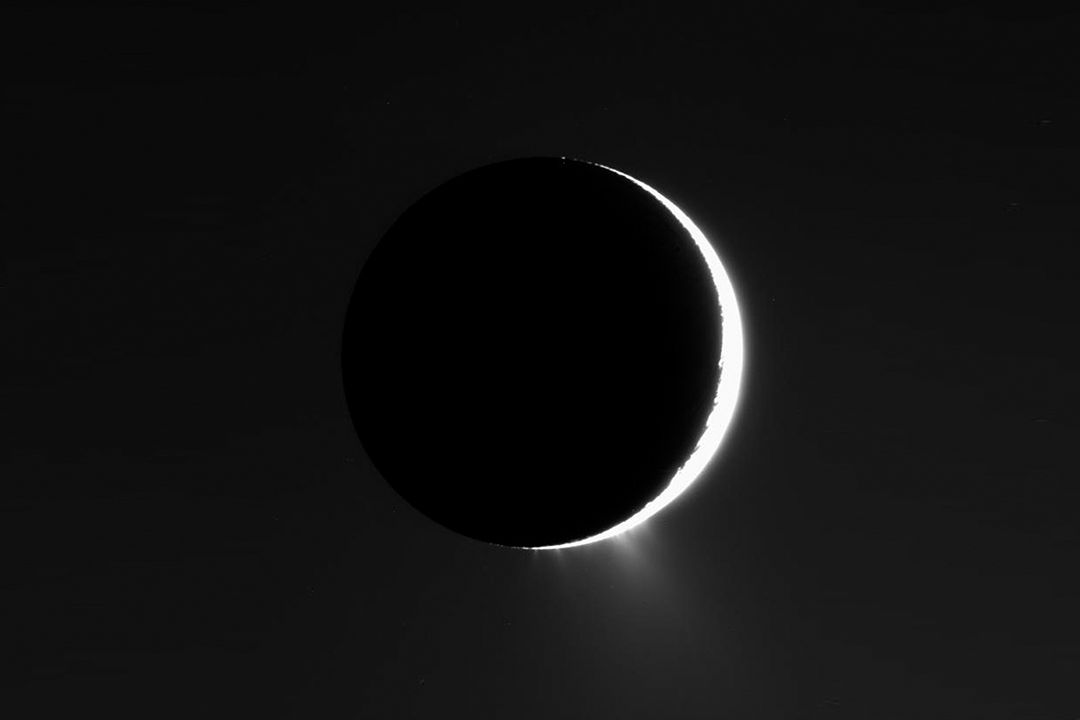 Ve výtryscích z Enceladu se našly nové organické sloučeniny. Snímek Saturnova měsíce (před Sluncem) je z roku 2007, pořídila jej sonda Cassini.
