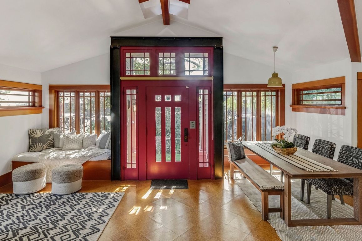Vstupní dveře do předního bungalovu mají jasnou červenou barvu. Vzhledem jsou ale hezky sjednocené s dřevěnými okny.