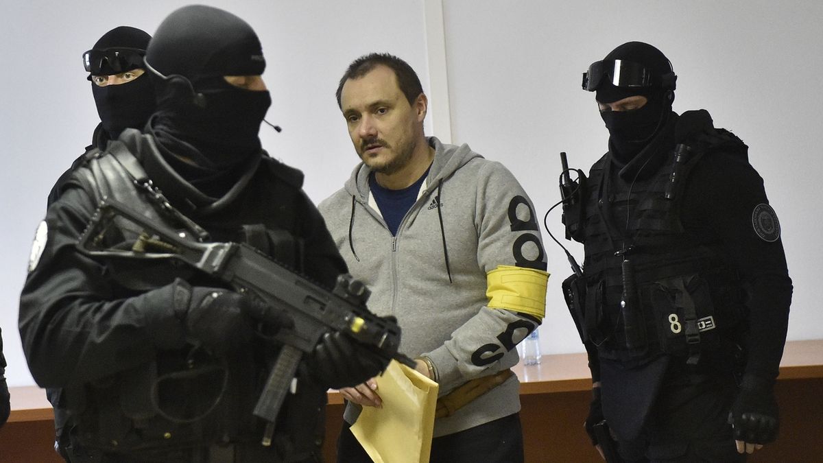 Obviněný Tomáš Szabó přichází v doprovodu stráže do jednací síně specializovaného trestního soudu v Pezinku.