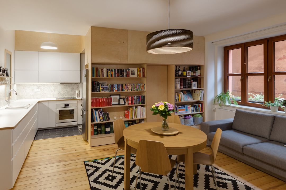 Nejdůležitějším prostorem je obývací pokoj propojený s kuchyňským koutem a velkou knihovnou, která je integrovaná do vestavěné překližkové stěny. 
