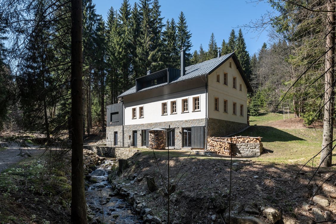 Nový dům stojí na hezkém pozemku obklopeném lesy, po jehož okraji protéká potok.