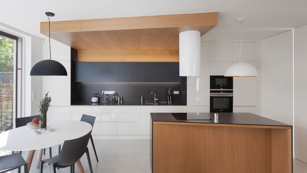 Kuchyňská sestava s pracovní plochou je umístěna podél celé jedné stěny místnosti.