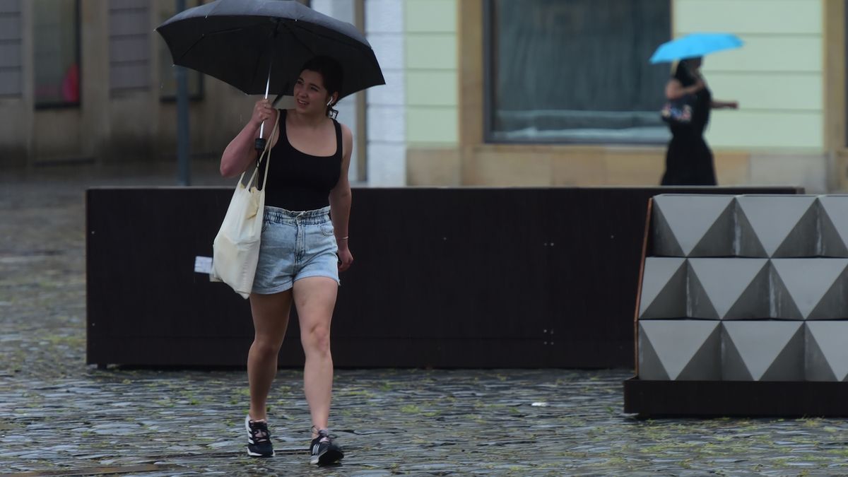 Žena prochází za vydatného deště centrem Olomouce 20. června 2022.
