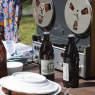 Pivo a magnetofon navazují atmosféru 60. let 20. století. Záběr na opékání buřtů, film Vlny.