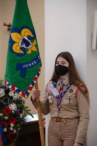 Skautka drží sborovou vlajku s typickou lilií ve znaku.