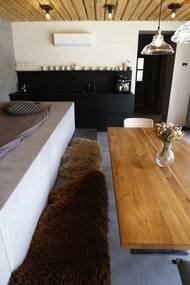 Jídelní stůl je ve středu místnosti, pár kroků od kuchyňské linky. Všechno tu jsou snadno dostupné prvky z běžných obchodů – lampy, nábytek…