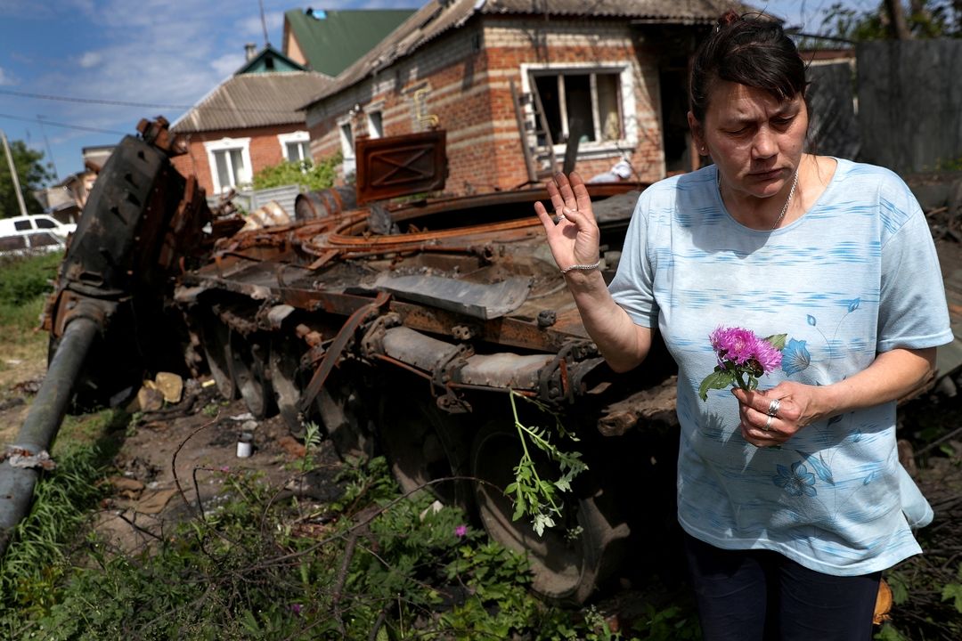 Тамара собирает цветы у подбитого российского танка в Харьковской области