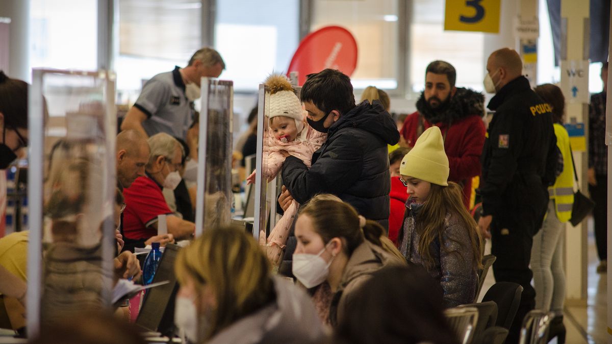 Lidé čekají u přepážek na potvrzení víz, které jim umožní pobyt v České republice.