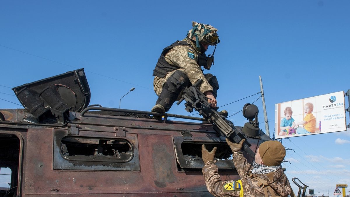 Ukrajinští vojáci kontrolují po boji poškozené vojenské vozidlo