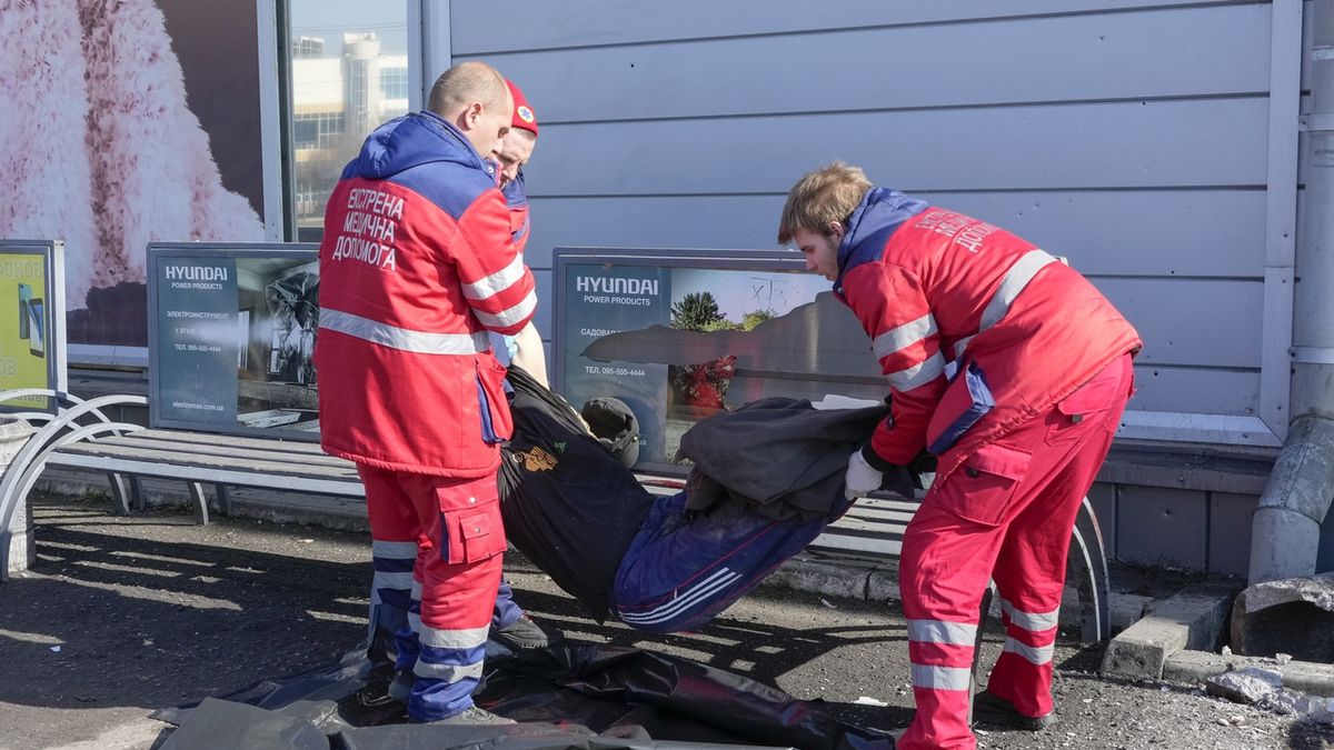 Záchranáři odklízejí tělo obyvatele Charkova, který zemřel při ruském ostřelování