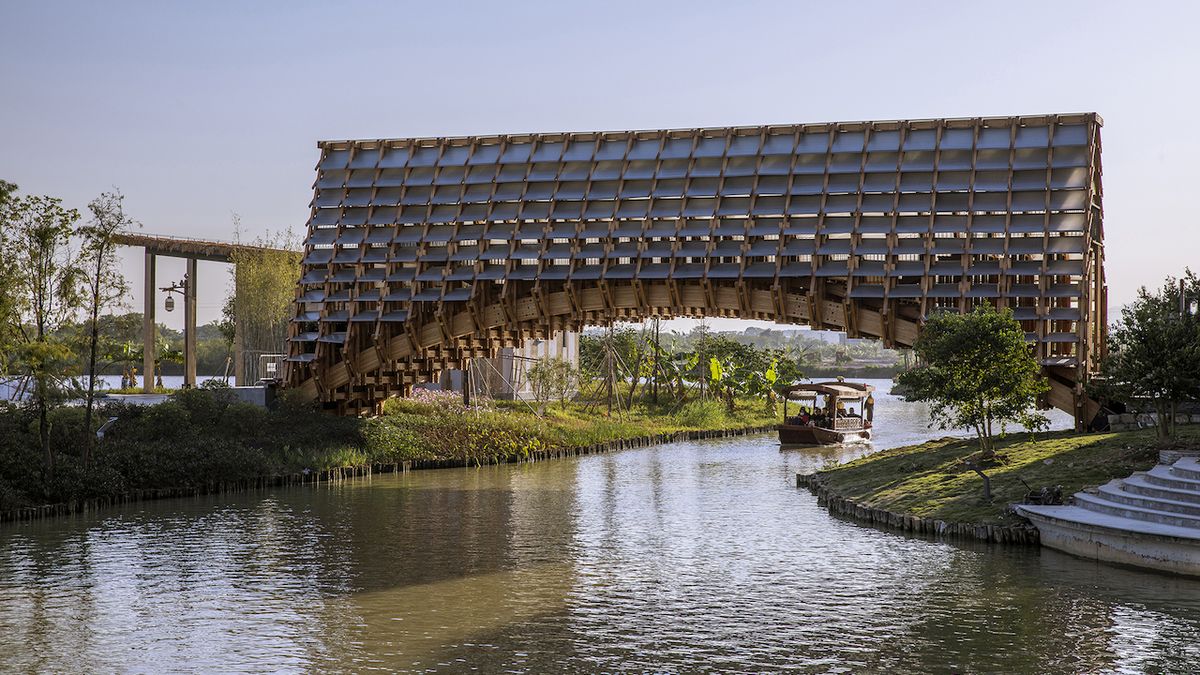 Klenutý dřevěný most nabízí spojení přes vodu i suché příjemné prostředí v období deště