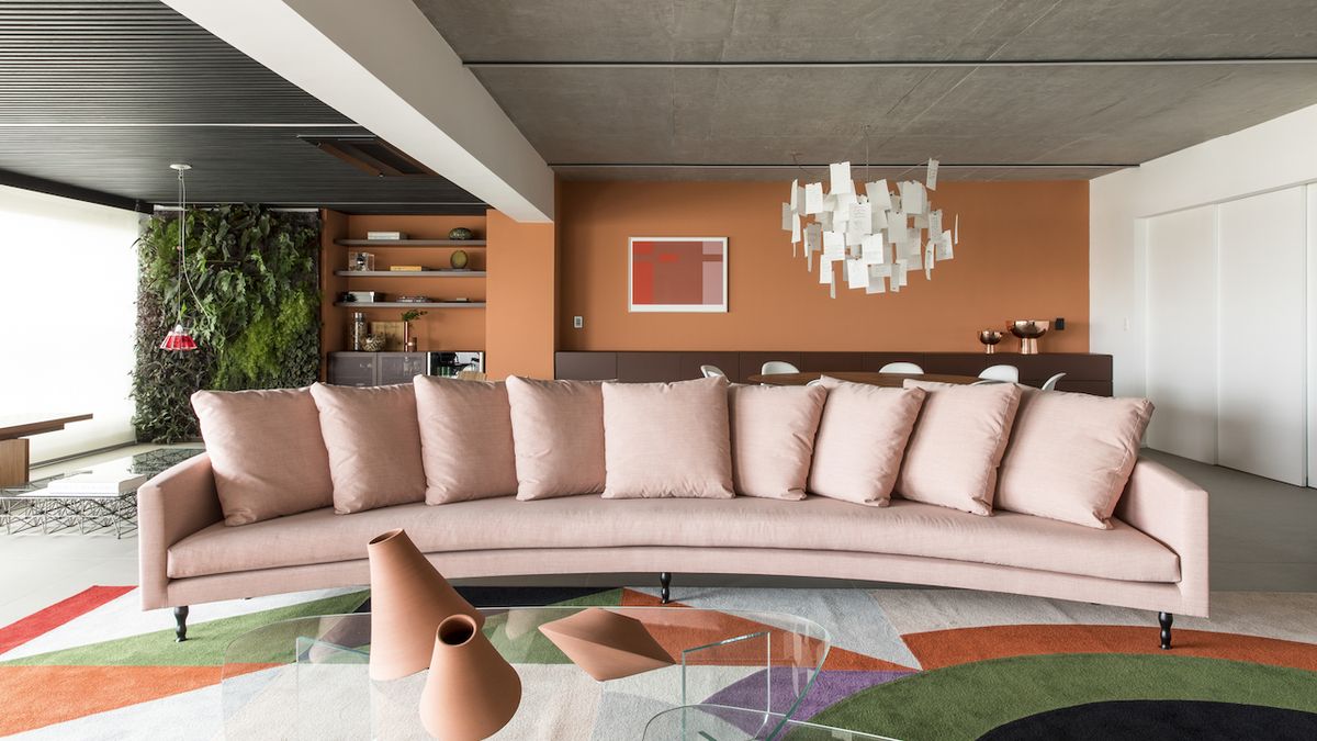 Centrálním prvkem obývacího pokoje je obří růžová sedací souprava