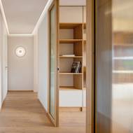 Prosklené posuvné příčky umožňují oddělit obývací pokoj od chodby, anebo jej s ní propojit. V obou případech má chodba dostatek světla