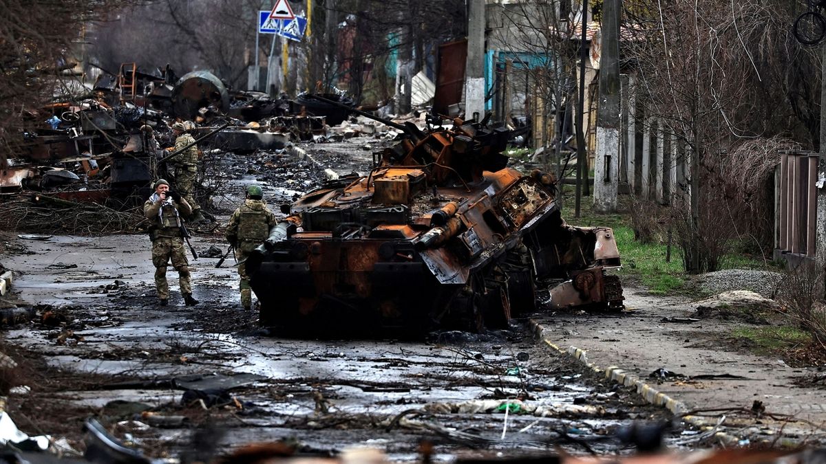 Ukrajinští vojáci se fotí u zničeného ruského tanku