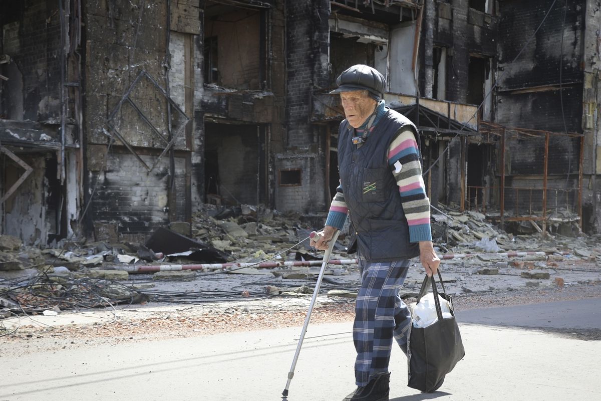 Житель Мариуполя проходит мимо разрушенного здания в районе, контролируемом пророссийскими сепаратистами