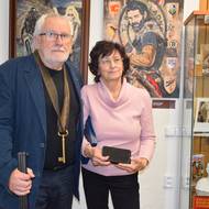 Výtvarník Miroslav Pospíšil s manželkou Jiřinou na výstavě obrazů věnovaných indiánům. V pozadí jedna zajímavost výstavy - portrét hokejisty Jardy Jágra.