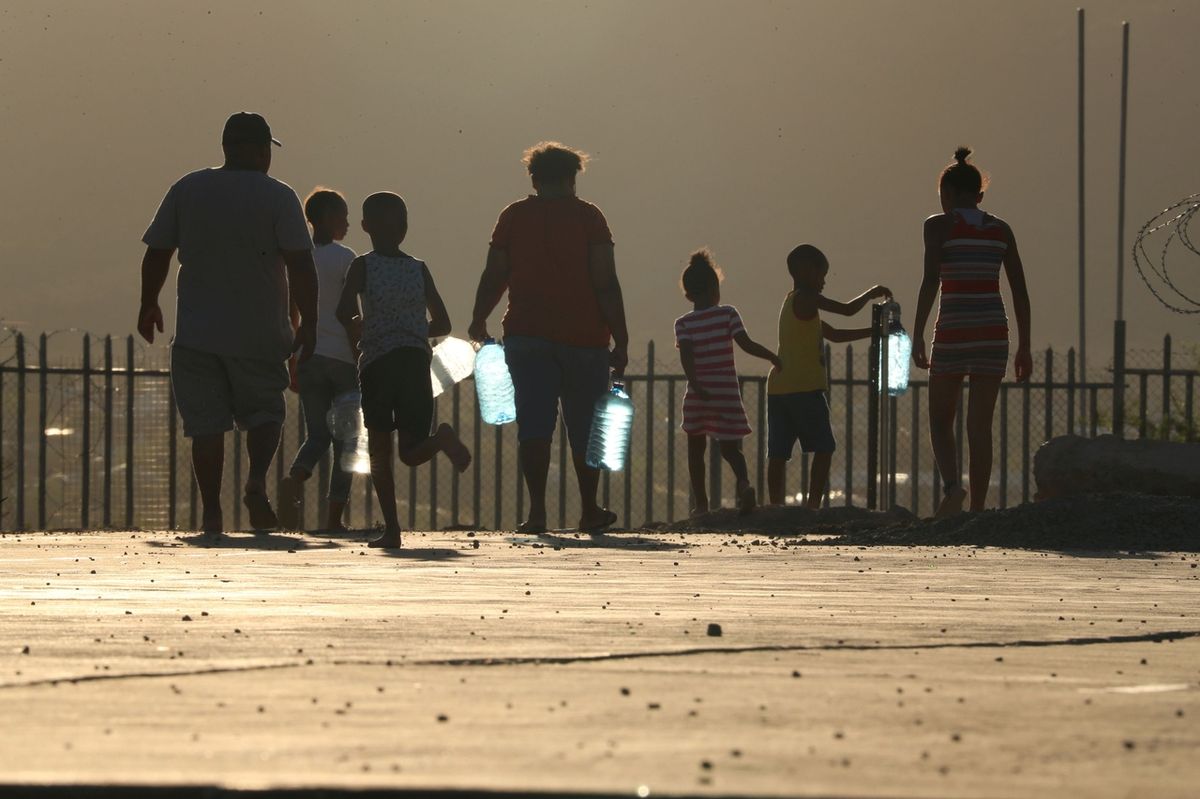 Lidé v jihoafrickém městě Graaff-Reinet jdou pro vodu. Snímek je z loňského listopadu, kdy oblast postihlo velké sucho.