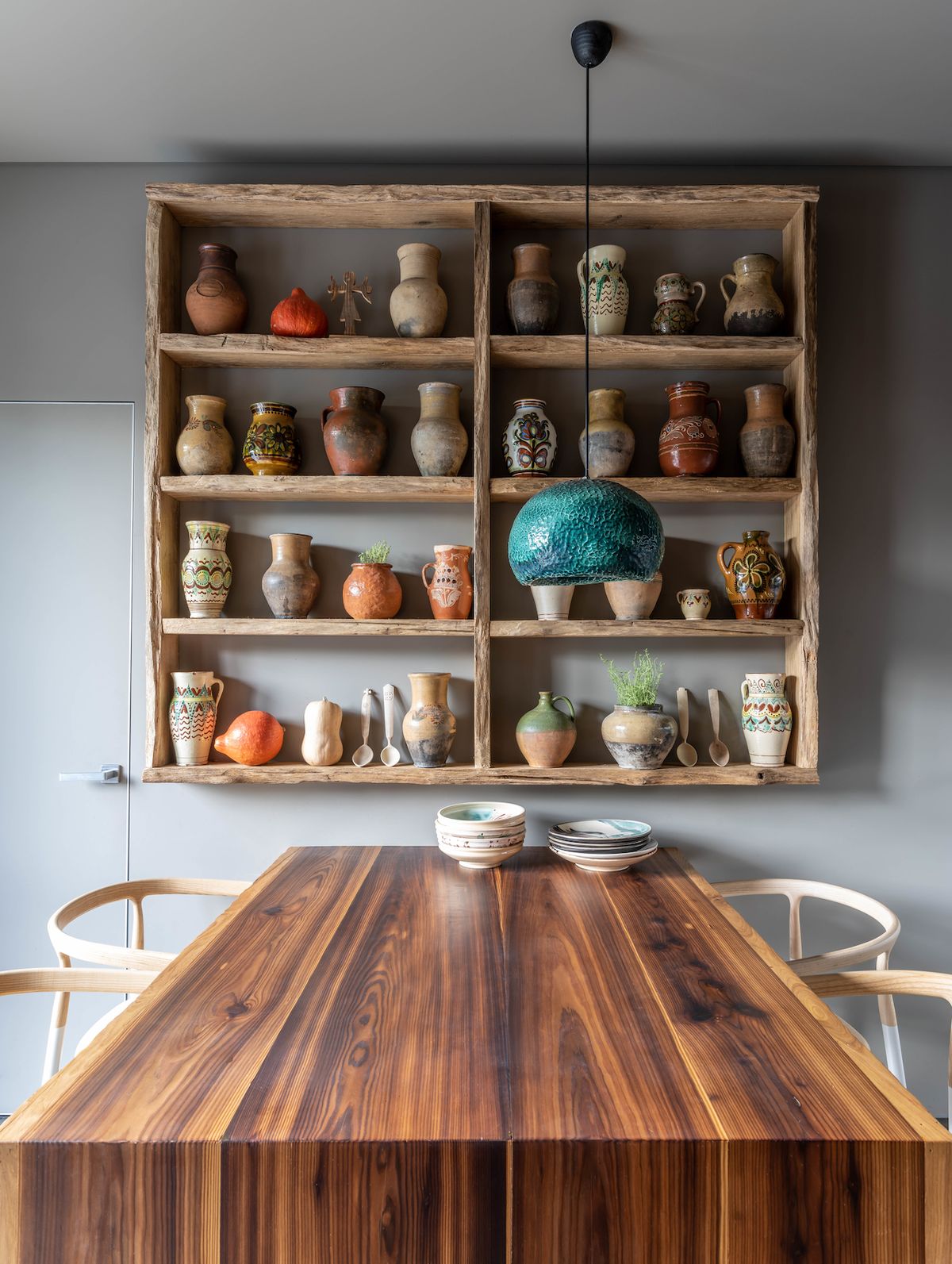 Nad masivním dřevěným stolem v tradiční ukrajinské kuchyni nechybí ani tzv. mysnyk - poličky určené k ukládání potravin. V této domácnosti zde nalezla místo keramika.