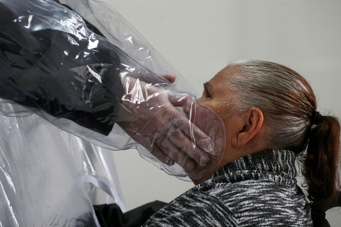 Muž se dotýká své matky v domově pro seniory v brazilském Sao Paulu