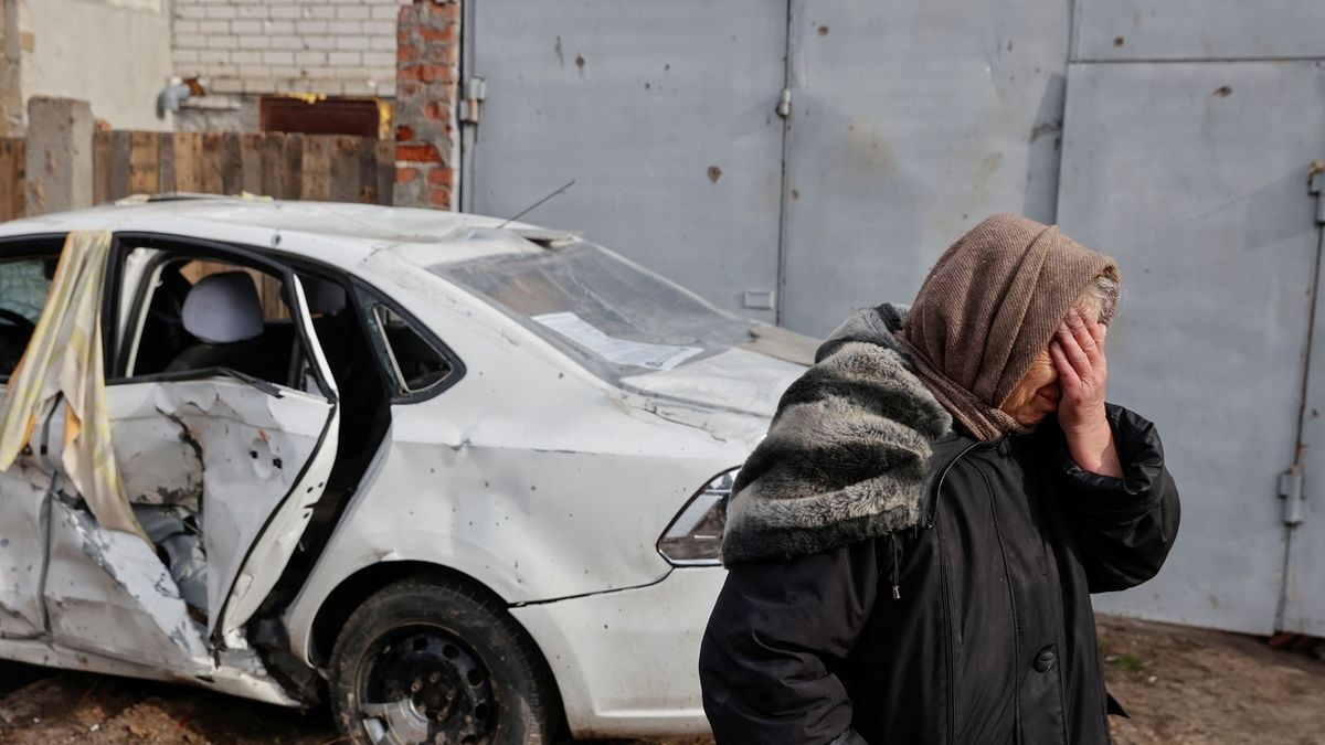 Obyvatelka Černihivu poblíž svého domu poškozeného ostřelováním a nálety