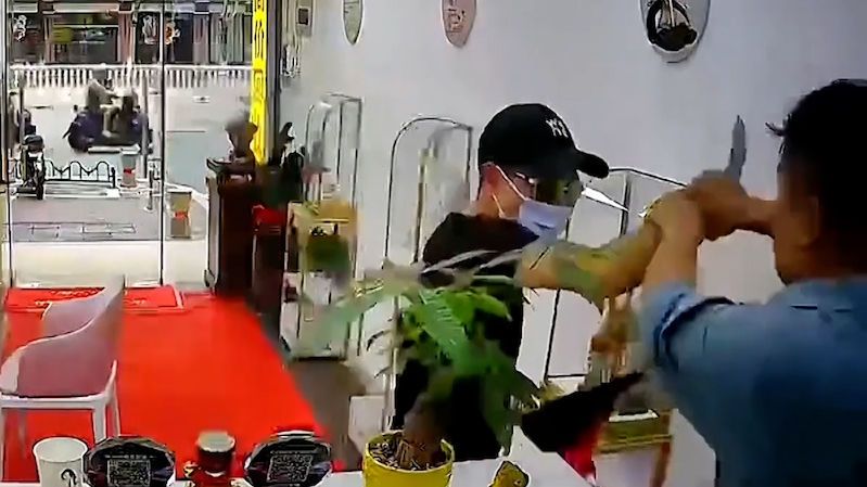Majitel klenotnictví se v Číně postavil ozbrojenému lupiči, přetahovanou natočila kamera