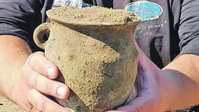 Jeden z archeologů se raduje z objevu keramické nádoby.