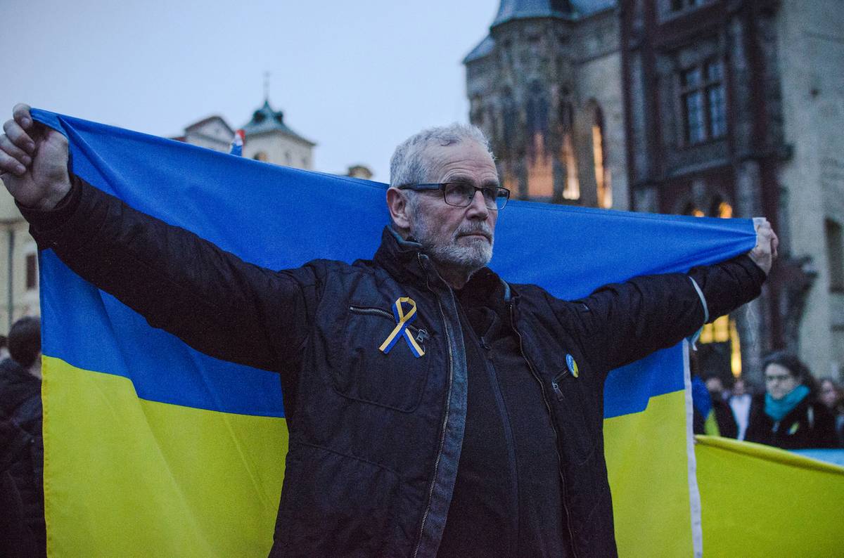 Demonstranti se objevili s modro-žlutými vlajkami a stužkami.