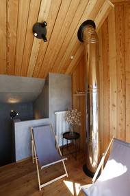 Před saunou se sprchou je malá odpočívárna u komínu od spodního krbu.