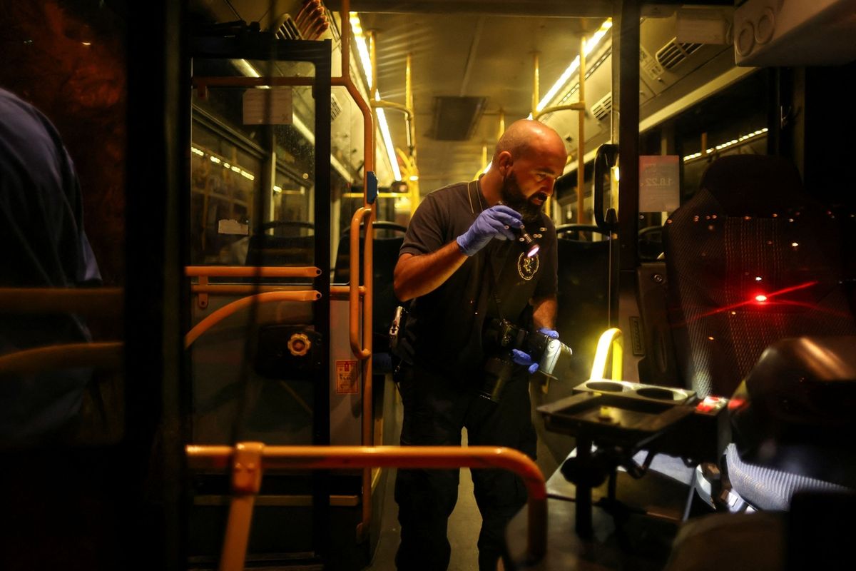 Policista ohledává autobus po útoku.