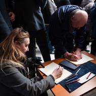 Lidé se podepisují do kondolenční knihy