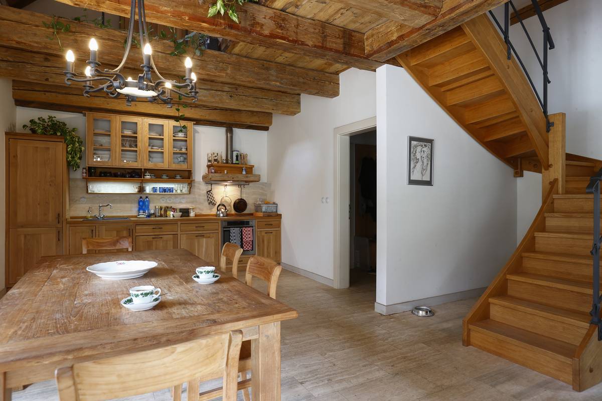 Uprostřed přízemí je jídelní stůl i psí miska vedle schodiště do podkroví.