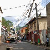 Technici obnovují elektrické vedení ve městě Gouyave v Grenadě, 2. července 2024