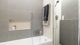 Do panelákové koupelny v šedých tónech se vešla vana i sprchový kout