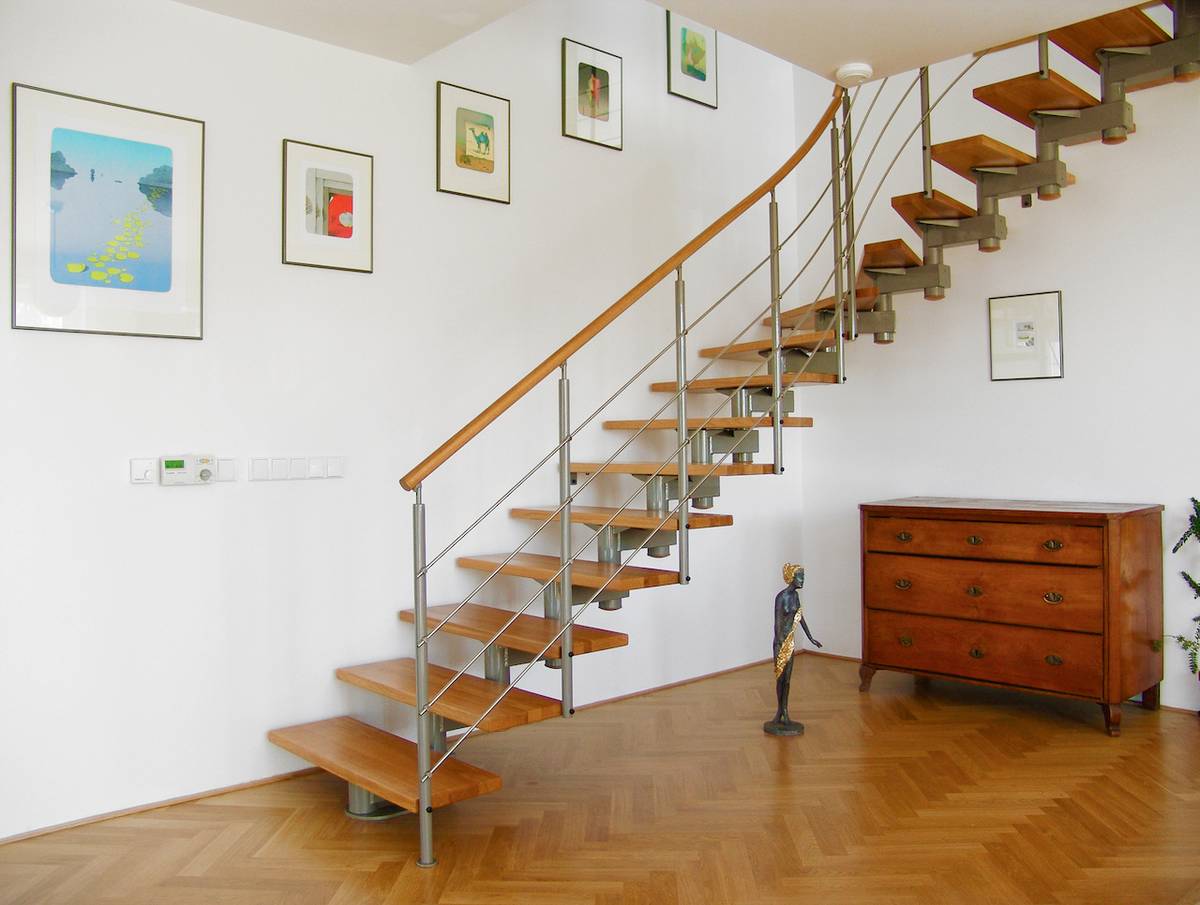 Jednoduché segmentové interiérové schodiště s dřevěnými stupni a páteří je prostorově úsporné.