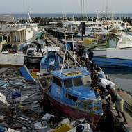 Rybáři vytlačují loď poškozenou hurikánem Beryl v Bridgetownu na Barbadosu, úterý 2. července 2024