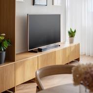 Černá obrazovka televize funguje jako zpestřující prvek interiéru zařízeného v klidných zemitých barvách