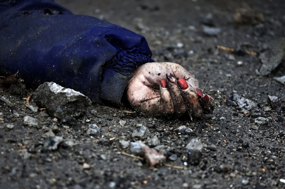 Mrtvá žena v ulicích Buči, kterou podle místních zastřelili ruští okupanti.