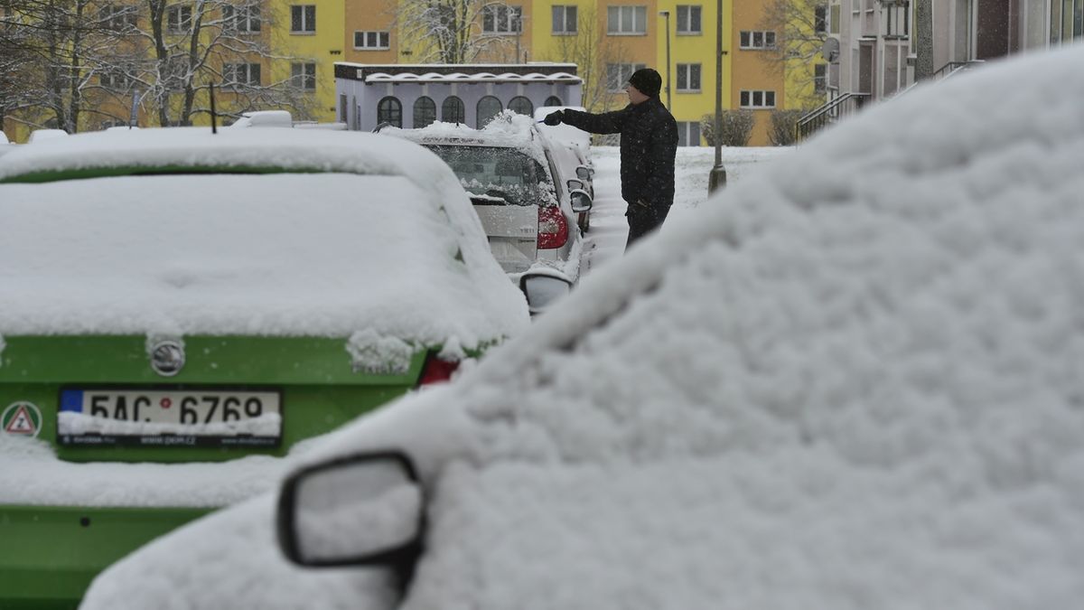 Husté sněžení a silný vítr od rána komplikuje provoz v Ústeckém kraji. Na snímku muž odklízí sníh ve Všebořicích v Ústí nad Labem.